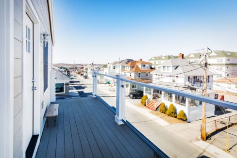 a balcony with a view of a street and houses.