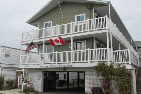 a two story building with a canadian flag on the balcony.