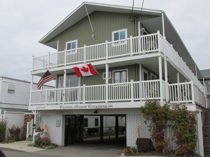 a two story building with a canadian flag on the balcony.