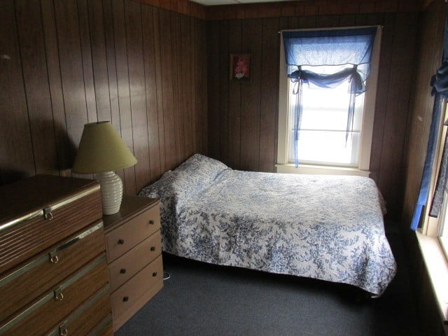 a bedroom with a bed, dresser and window.