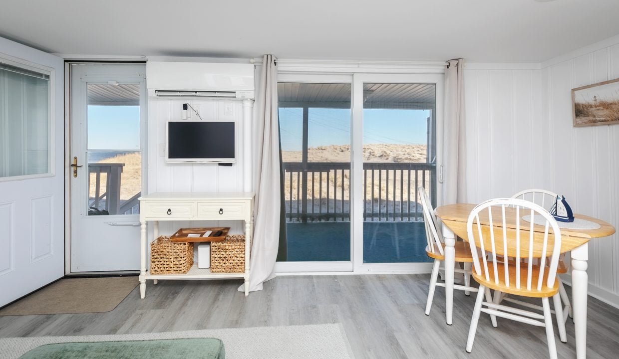 Minimalist beach house interior with sliding doors leading to a balcony.