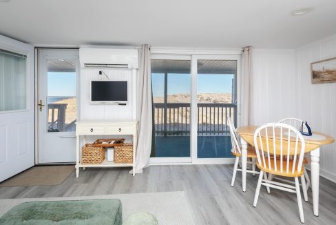 Minimalist beach house interior with sliding doors leading to a balcony.