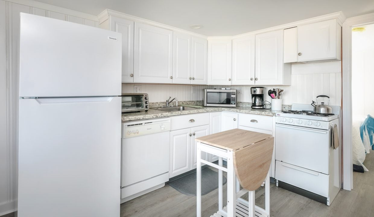 Bright, modern kitchen interior with white appliances and cabinetry.