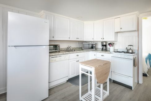 Bright, modern kitchen interior with white appliances and cabinetry.