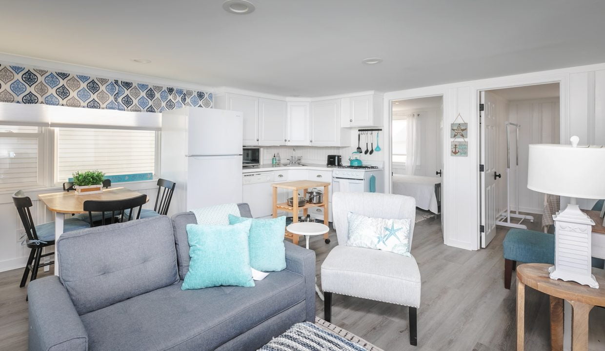 Modern and bright coastal-themed living space with an open-plan kitchen and dining area.