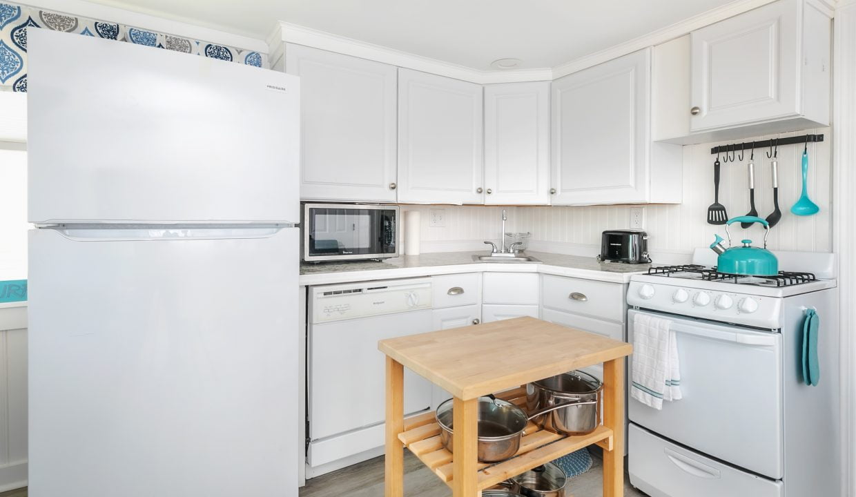 A bright, compact kitchen with white appliances and cabinets.