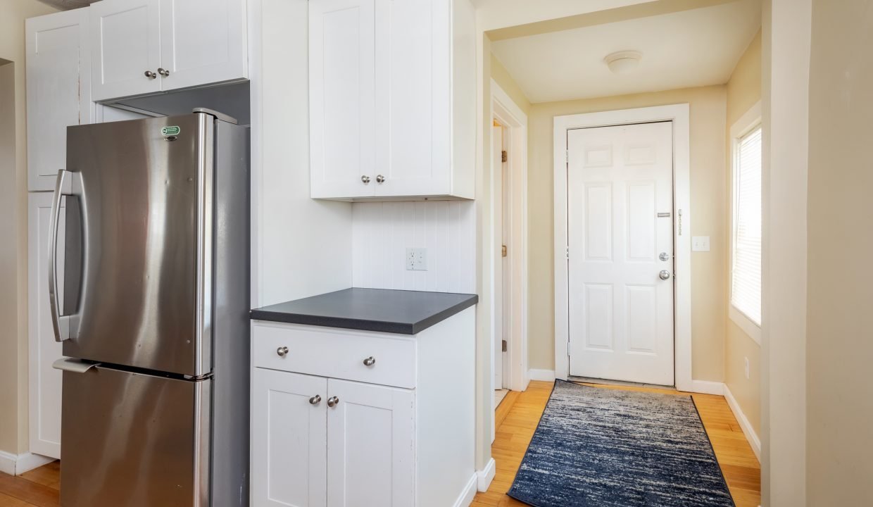 a stainless steel refrigerator in a white kitchen.