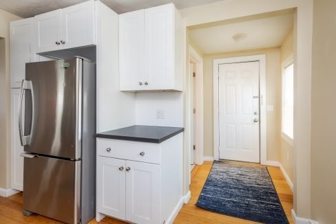 a stainless steel refrigerator in a white kitchen.