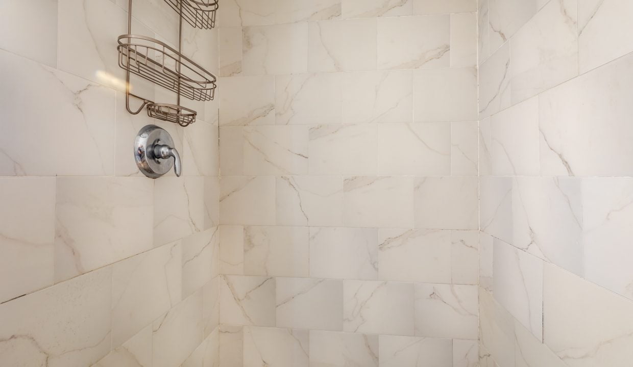 a bathroom with a shower head and a towel rack.