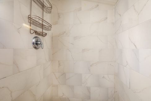 a bathroom with a shower head and a towel rack.