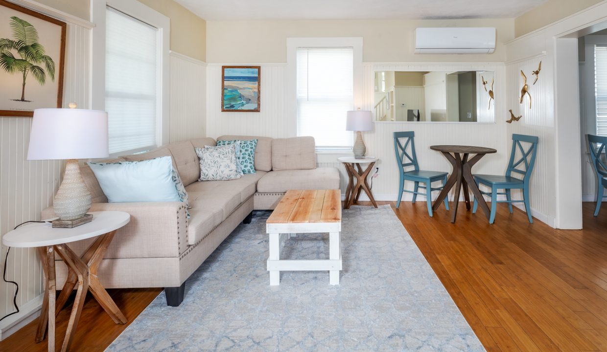 a living room filled with furniture and a wooden floor.