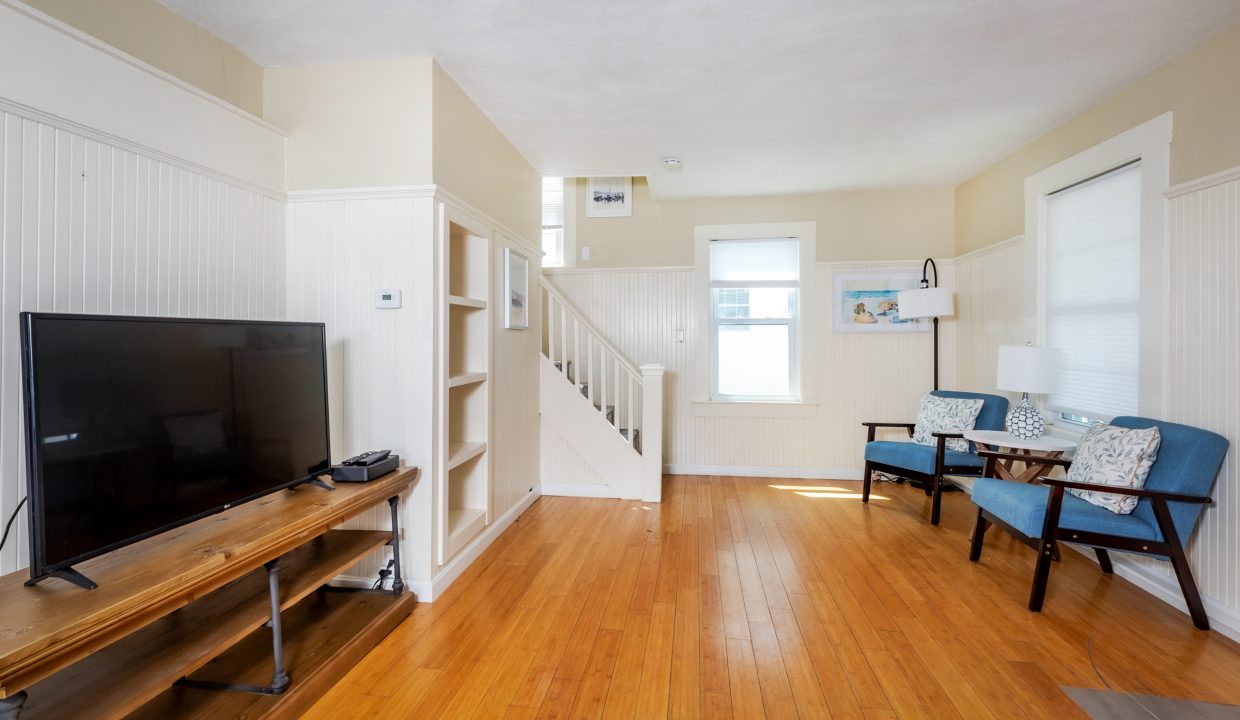 a living room with hard wood floors and a flat screen tv.