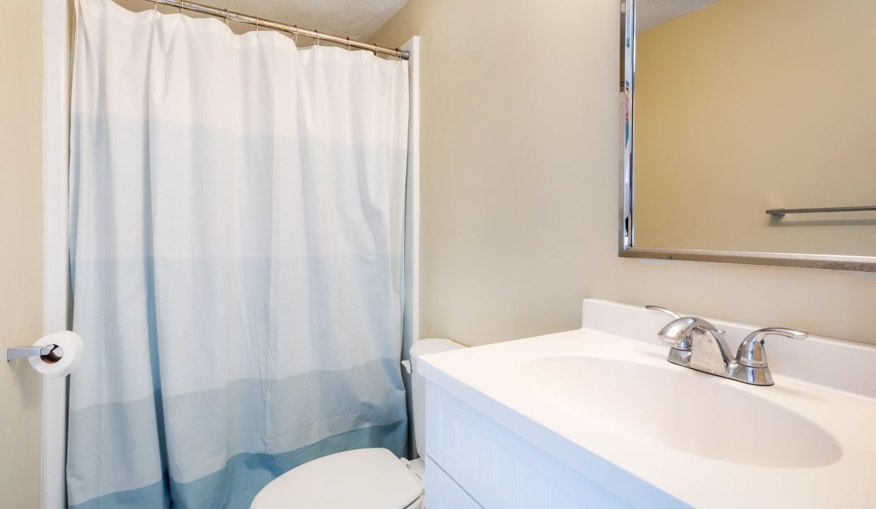 a bathroom with a white toilet and a blue shower curtain.