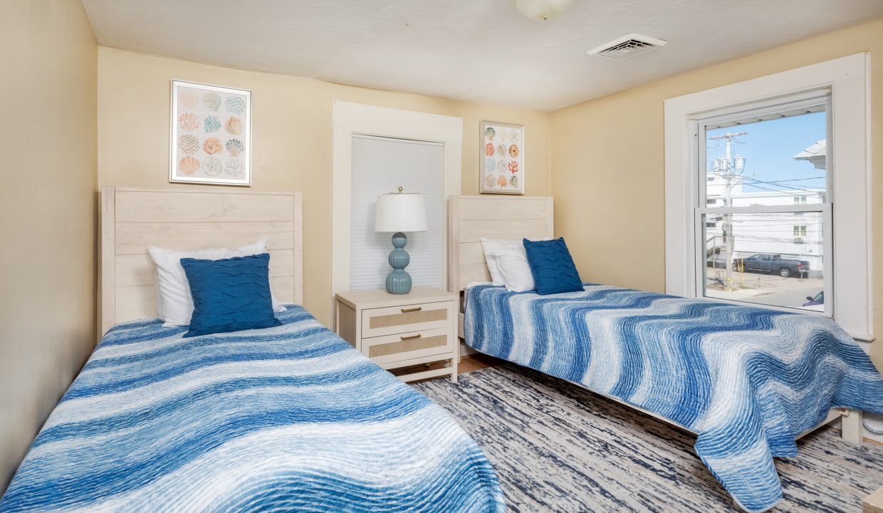 a bedroom with two beds and a window.