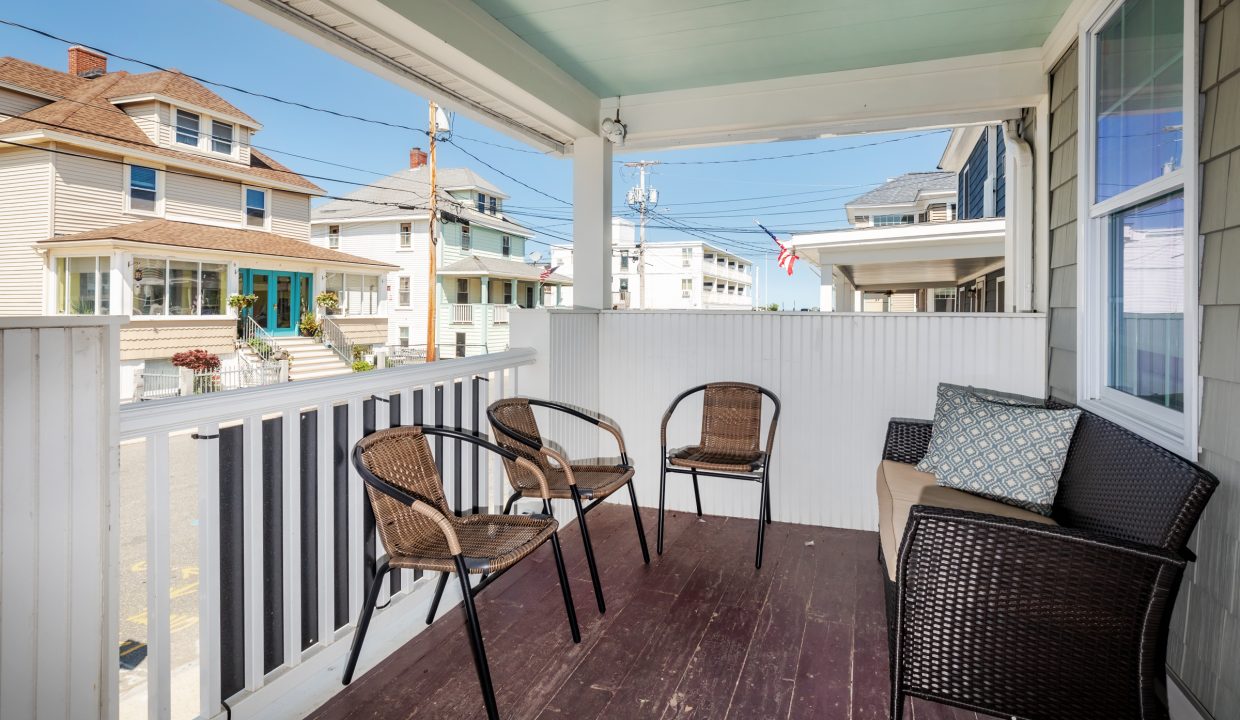 a porch with chairs and a table on it.