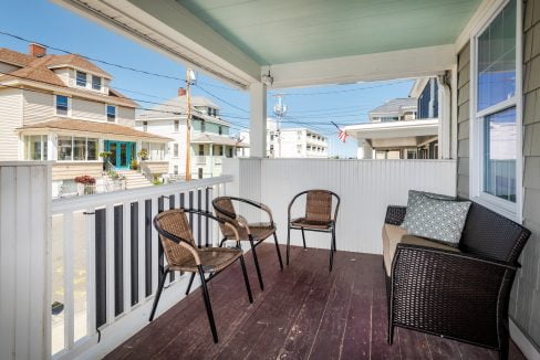 a porch with chairs and a table on it.