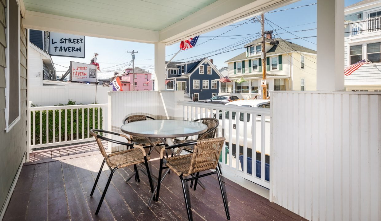 a porch with a table and chairs on it.