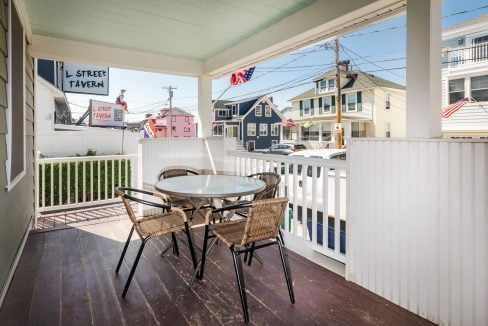 a porch with a table and chairs on it.