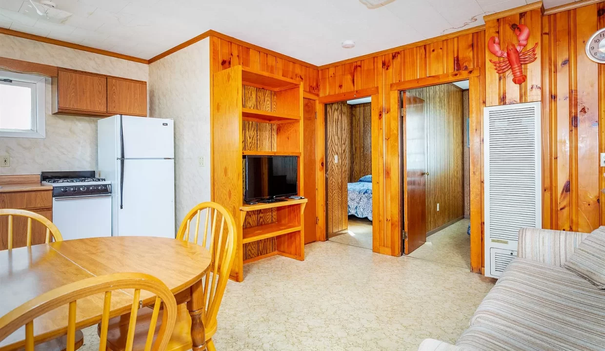 a kitchen and living room with wood paneling.