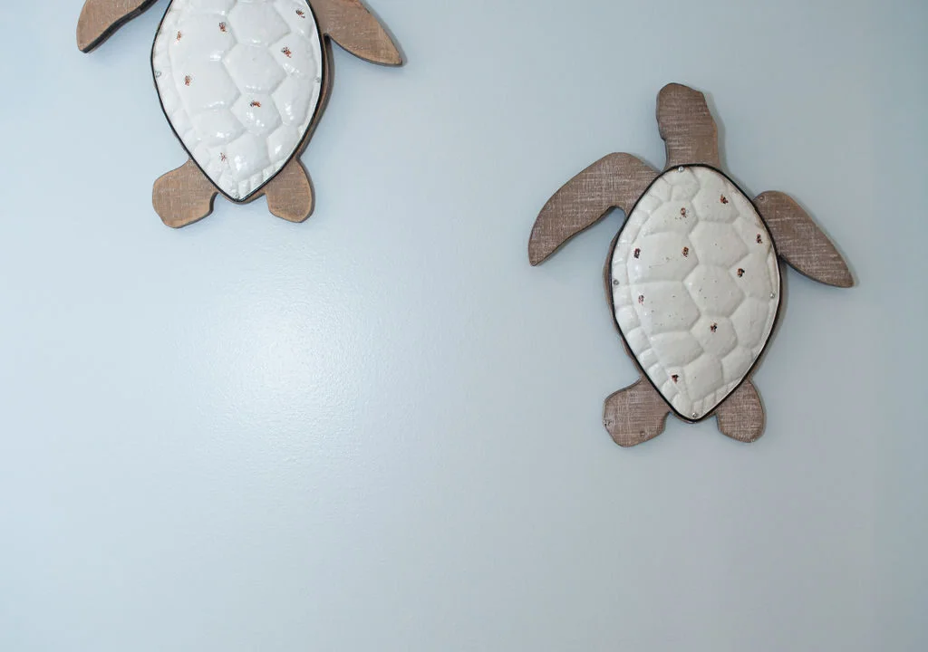 two wooden turtles mounted to the side of a wall.