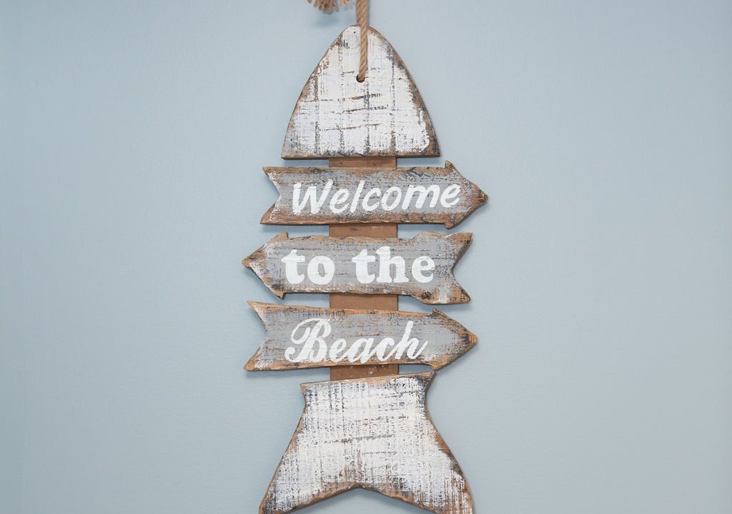 a wooden sign that says welcome to the beach.