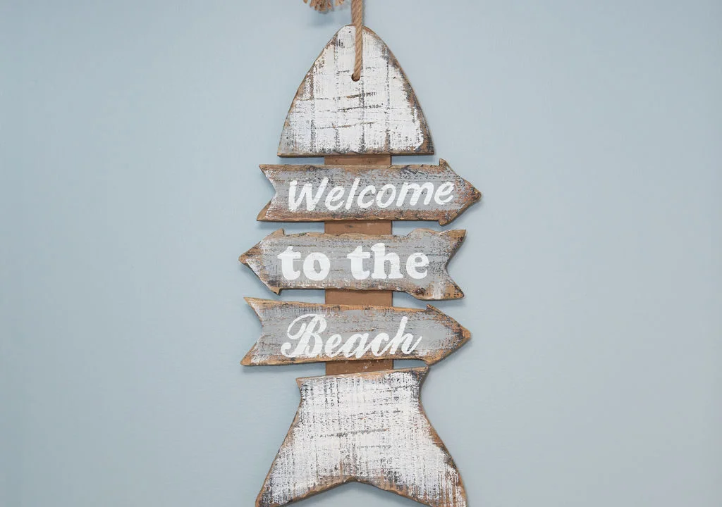 a wooden sign that says welcome to the beach.