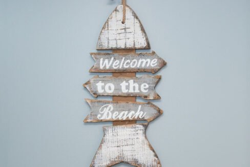 a wooden sign that says welcome to the beach.