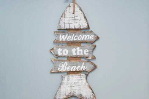 a wooden sign that says welcome to the beach.
