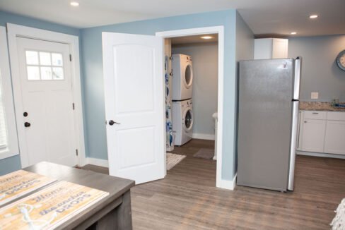 a kitchen with a refrigerator, sink, and washer and dryer.