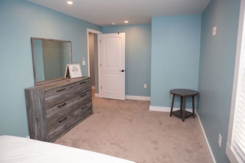 a bedroom with blue walls and a dresser.