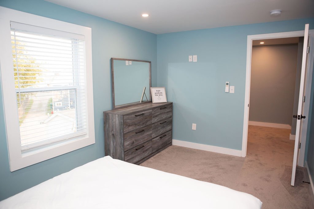 a bedroom with blue walls and a dresser.