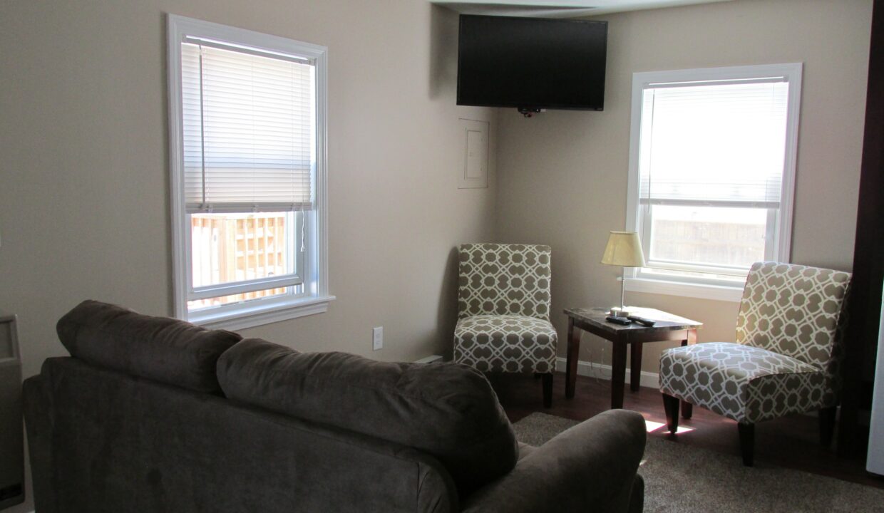 a living room with two chairs and a flat screen tv.