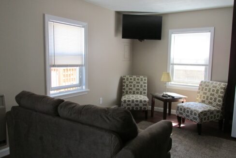 a living room with two chairs and a flat screen tv.