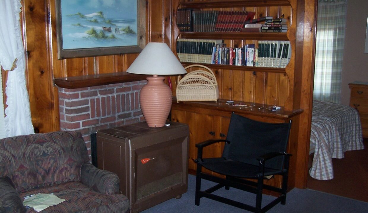 a living room with a chair and a lamp.