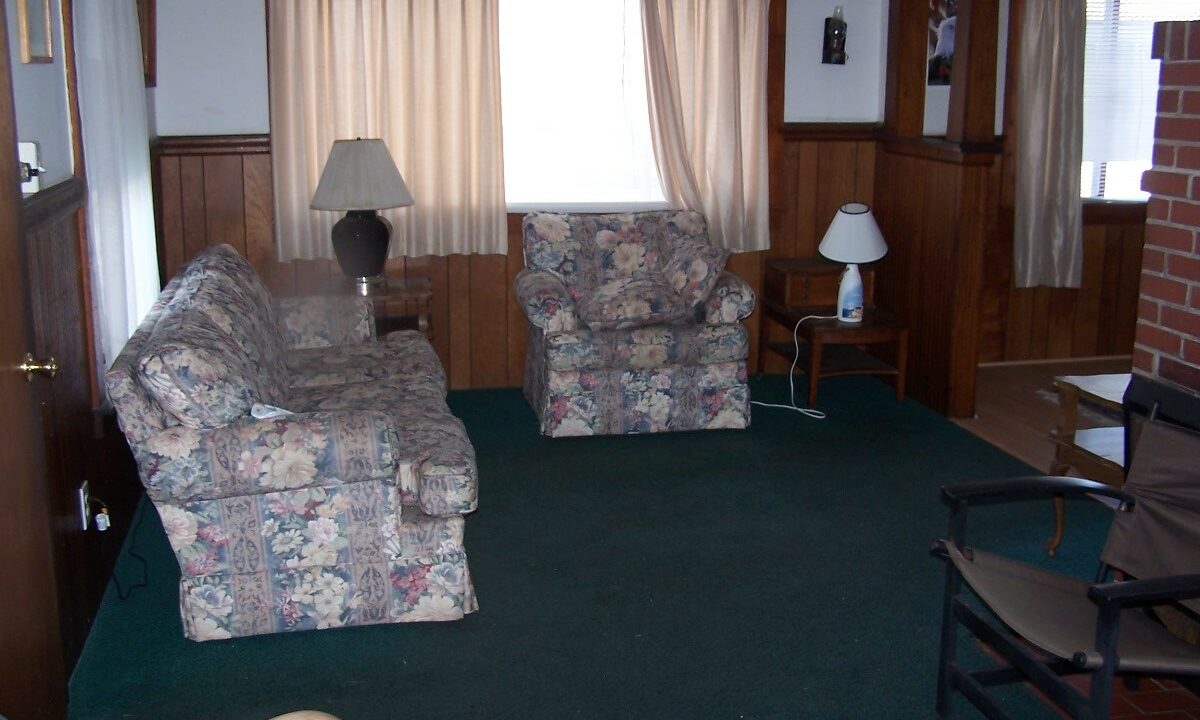 a living room filled with furniture and a lamp.