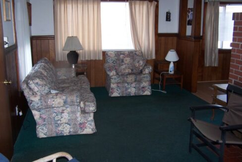 a living room filled with furniture and a lamp.