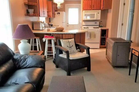 a living room filled with furniture and a kitchen.