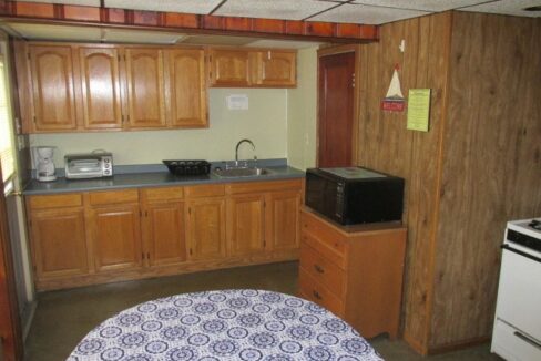 a kitchen with wooden cabinets and a blue and white table cloth.