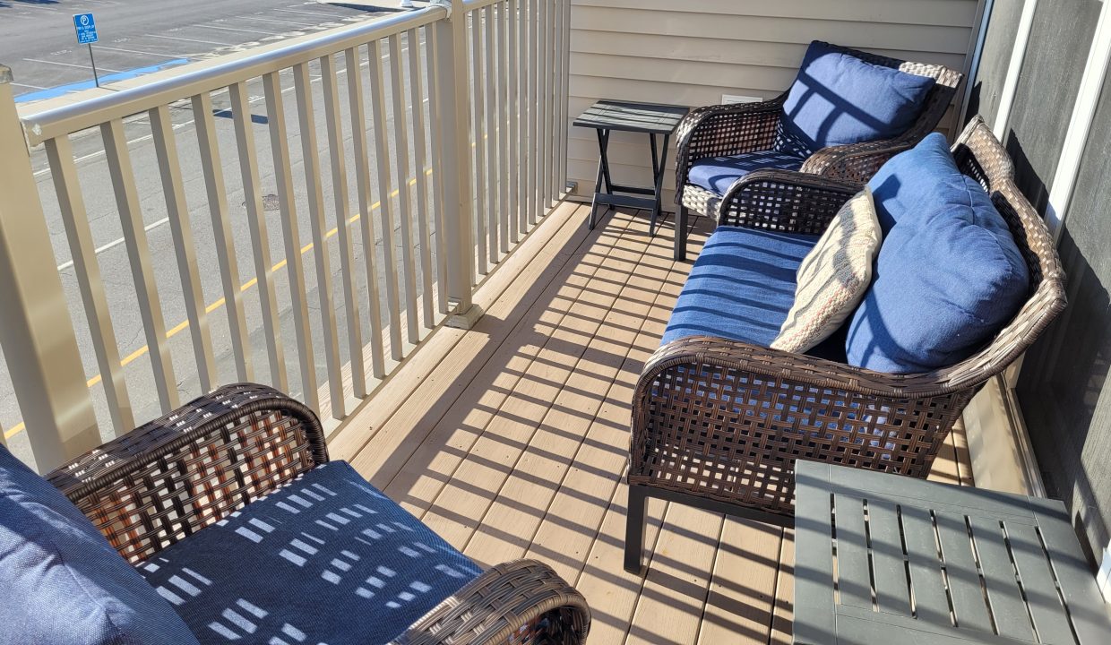 a couple of chairs sitting on top of a wooden deck.