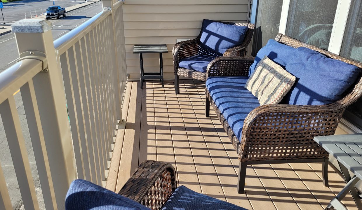 a couple of chairs sitting on top of a wooden deck.