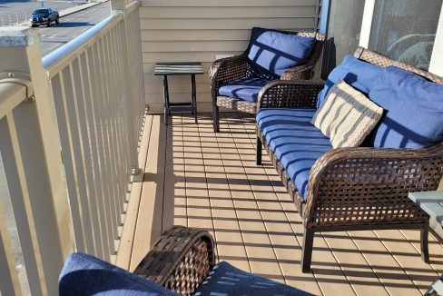 a couple of chairs sitting on top of a wooden deck.