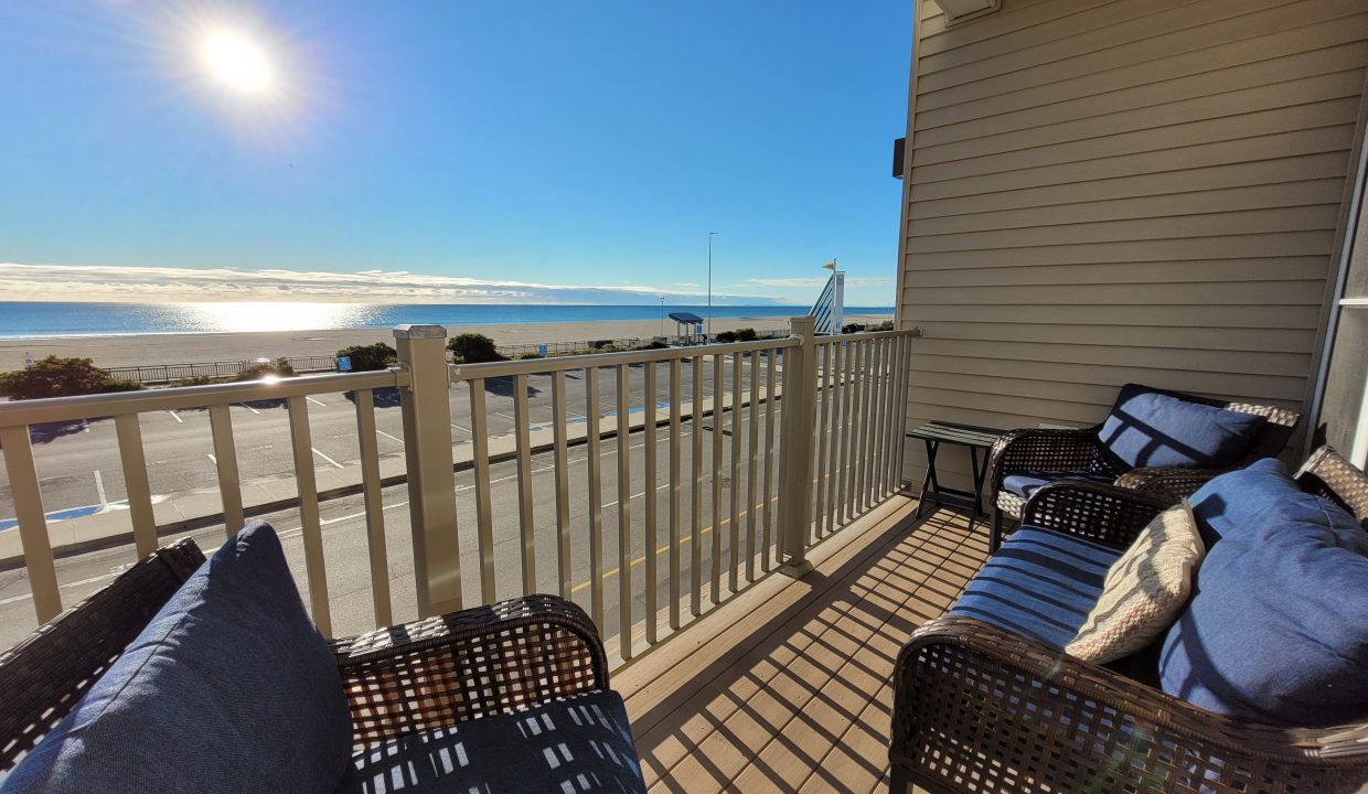 a balcony with wicker furniture and a view of the ocean.