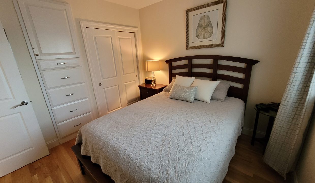 a bedroom with a bed, dresser, and mirror.