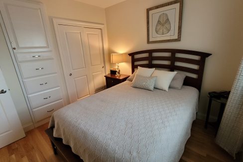 a bedroom with a bed, dresser, and mirror.