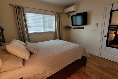 a bedroom with a large bed and a flat screen tv.