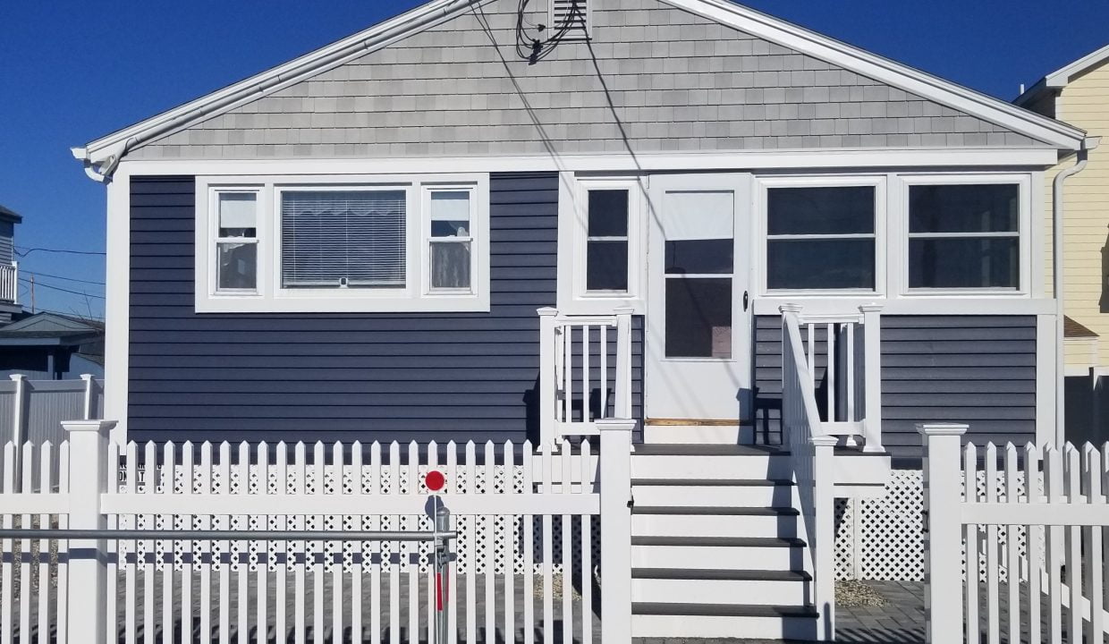 a house with a white picket fence in front of it.