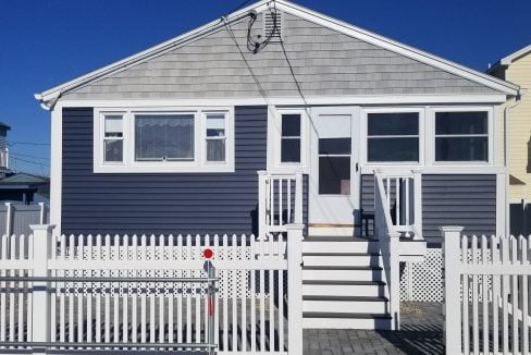 a house with a white picket fence in front of it.