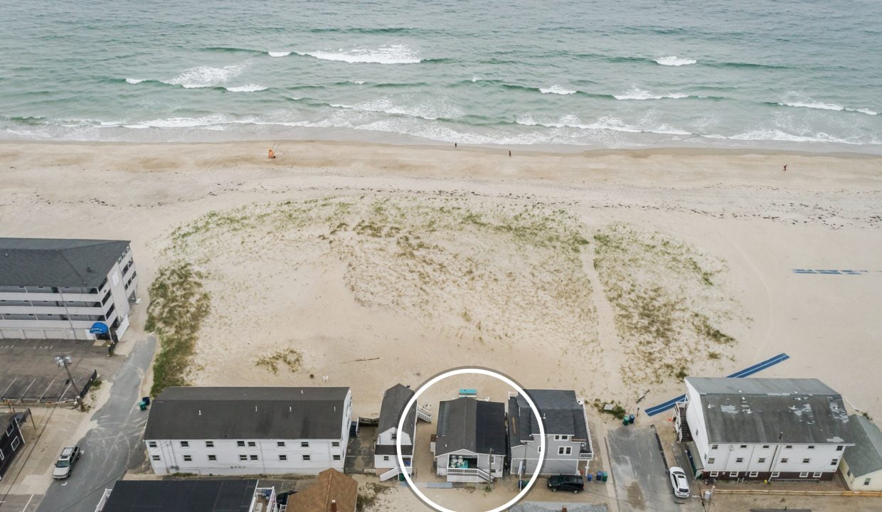 an aerial view of a beach with houses and the ocean in the background.