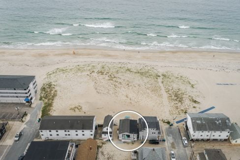 an aerial view of a beach with houses and the ocean in the background.