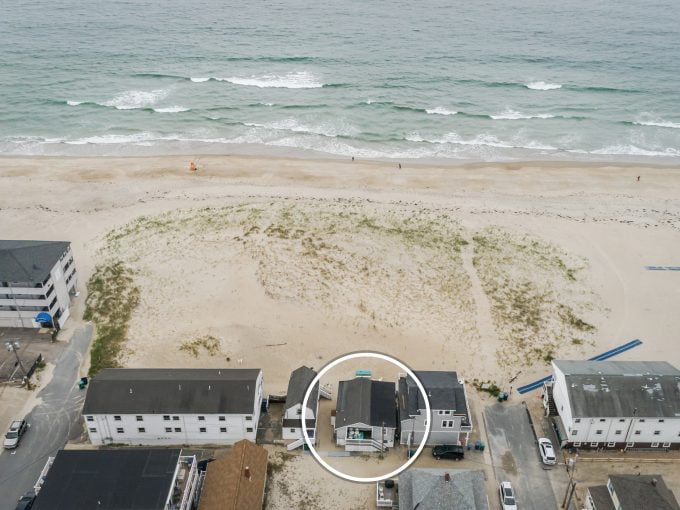 an aerial view of a beach with houses and the ocean in the background.